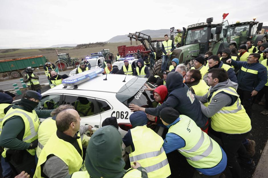 Agricultores mueven coches de la Guardia Civil para acceder a Pamplona este jueves.