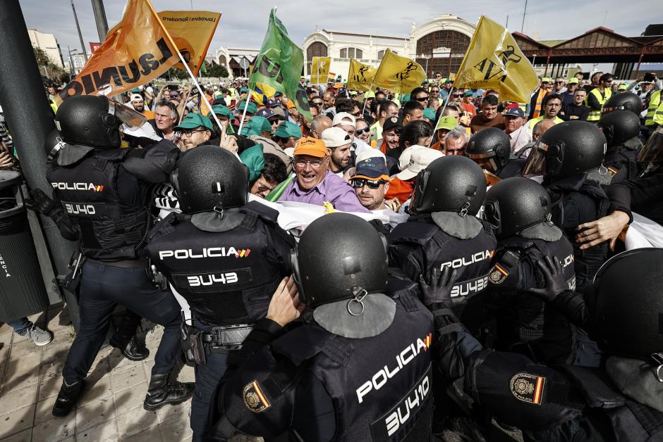 Agricultores tras el cordón policial durante la manifestación en Valencia