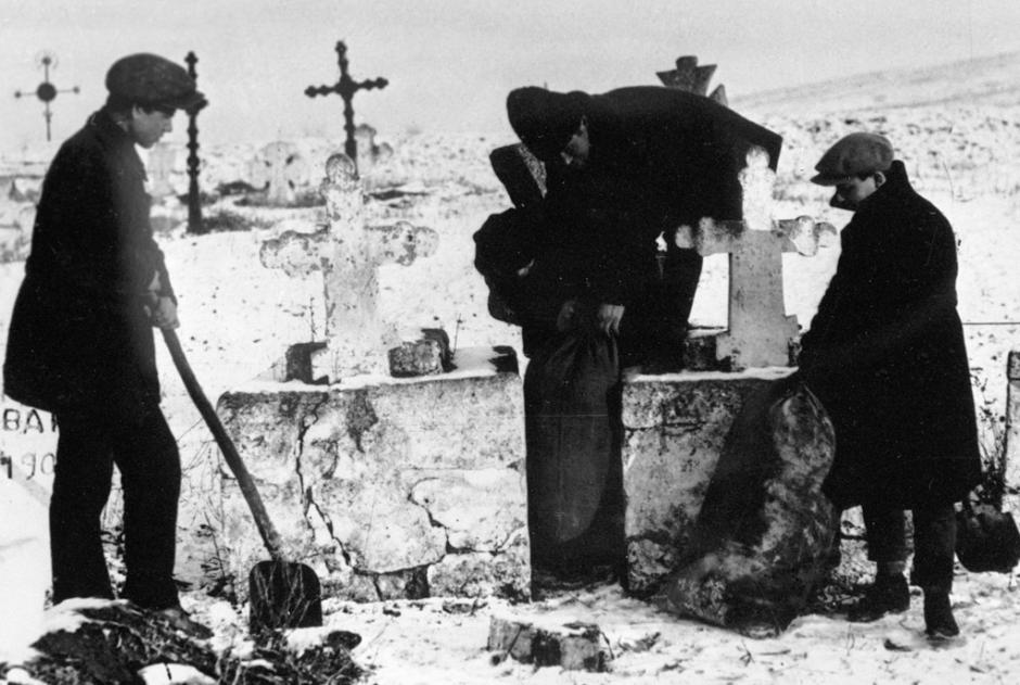 El pie de foto dice "YCLers se apoderan de grano de kulaks que estaba escondido en el cementerio, Ucrania, 1930"