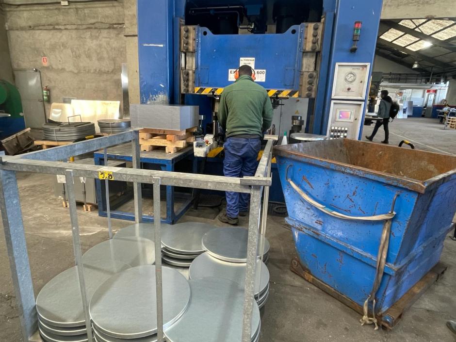 Un operario mete las placas de aluminio en una prensa