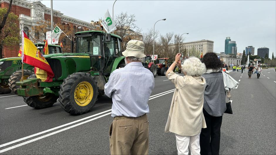 Varias personas aplauden al paso de los tractores por el Paseo de la Castellana
