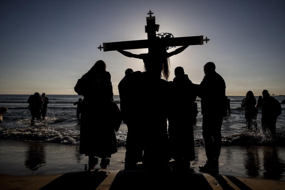 Varios cofrades portan una imagen de Cristo a la orilla de la playa, en Valencia, en 2023