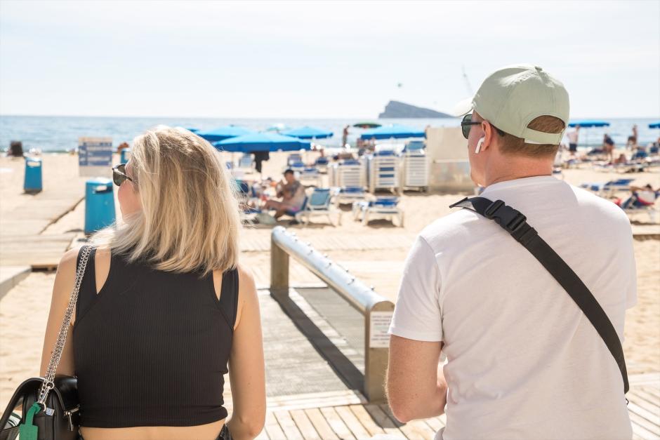 Una pareja llega a la playa de Poniente, en Benidorm, Alicante