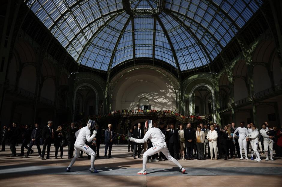 French national fencing squad show their skills during French president's visit to Le Grand Palais, in Paris, on April 15, 2024, 100 days ahead of the Paris 2024 Olympic Games.during a visit to Le Grand Palais, in Paris, on April 15, 2024, 100 days ahead of the Paris 2024 Olympic Games. Le Grand Palais will host the fencing and taekwondo competition events during the Paris 2024 Olympic Games. (Photo by Yoan VALAT / POOL / AFP)