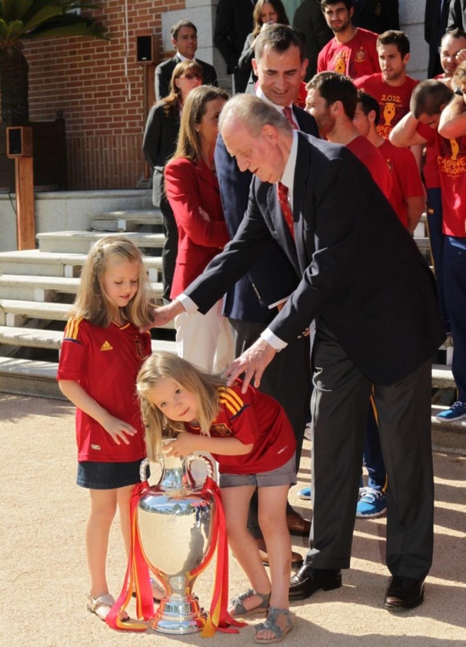 El Rey Don Juan Carlos con sus nietas Leonor y Sofía, que juegan con la copa de la Selección Española de Fútbol tras ganar la Eurcopa de 2012
