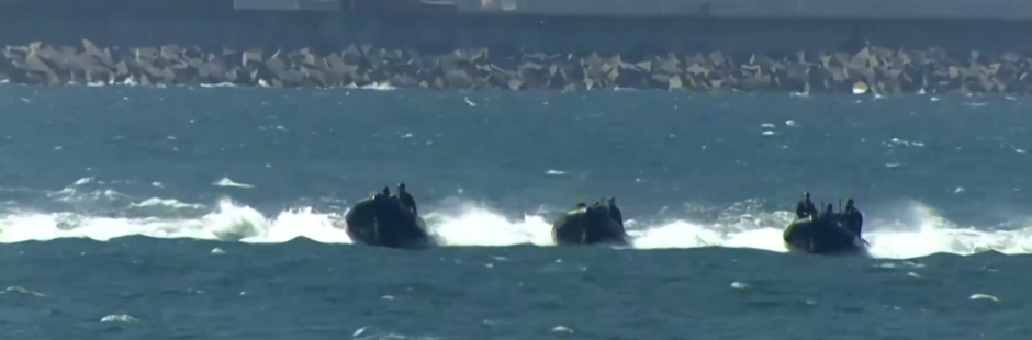 Lanchas de desembarco se aproximan a la bahía de Gijón desde el grupoo naval para afianzar las posiciones en la playa