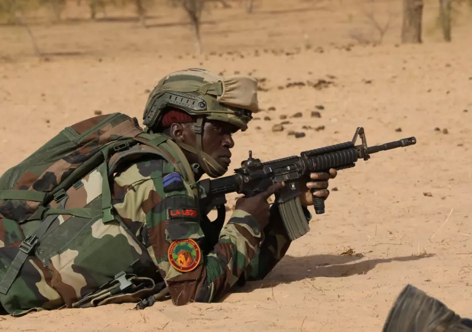 Un miembro de las fuerzas armadas senegalesas espera a que un oficial de seguridad lo saque del campo de tiro durante African Lion 2024.