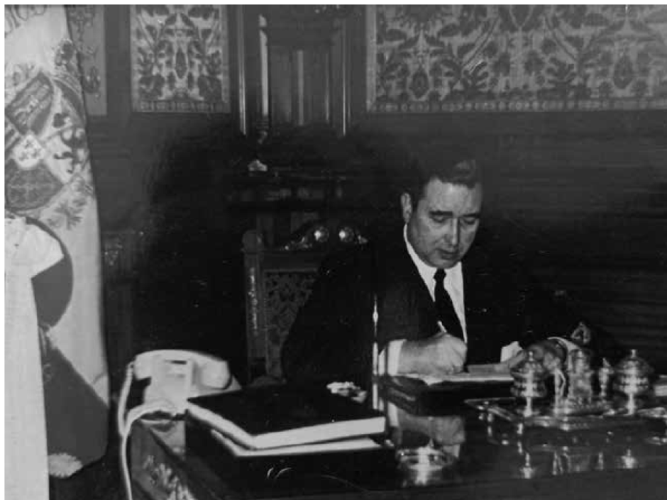 Juan María de Araluce en su despacho de la Diputación de Guipúzcoa.
A su derecha, la bandera del tercio requeté de San Ignacio