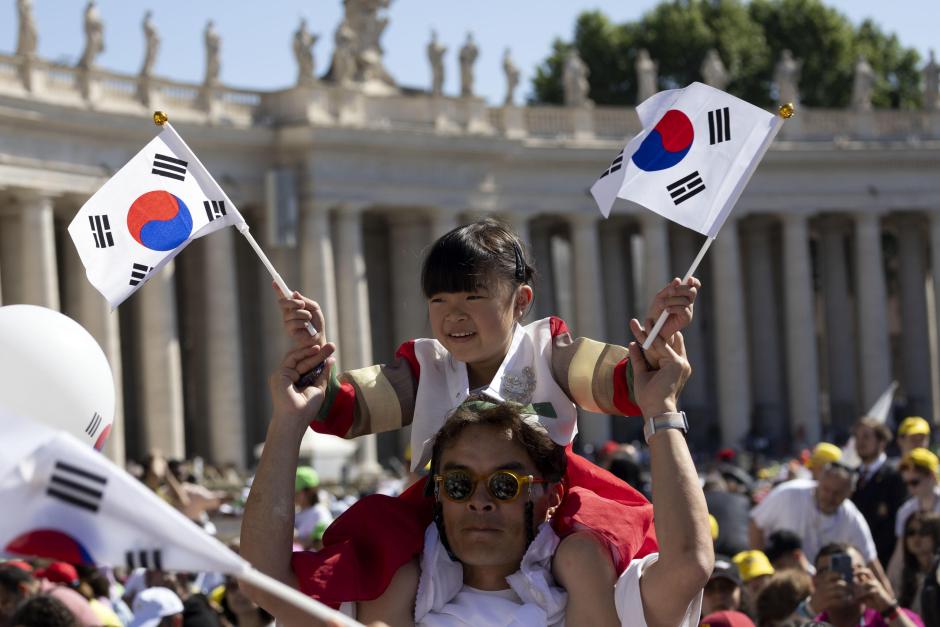 Vatican City (Vatican City State (holy See)), 26/05/2024.- A girl on a man's shoulders waves small South Korean flages as faithful wait in Saint Peter's Square for the arrival of the Pope ahead of a mass on World Children's Day at Saint Peter's Basilica, in Vatican City, 26 May 2024. The World Children's Day celebration move to St. Peter's Square on 26 May, to be presided over by Pope Francis, and will culminate with the Angelus and the Pope's greeting to children from around the world. (Papa, Corea del Sur) EFE/EPA/MASSIMO PERCOSSI