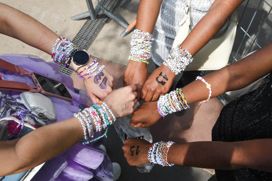 Un grupo de fans muestra sus pulseras de la amistad