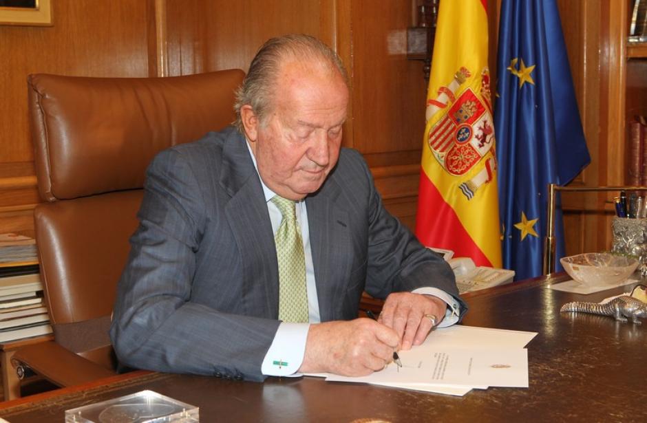 Don Juan Carlos firma en su despacho la carta en la que comunica su desea de abdicar