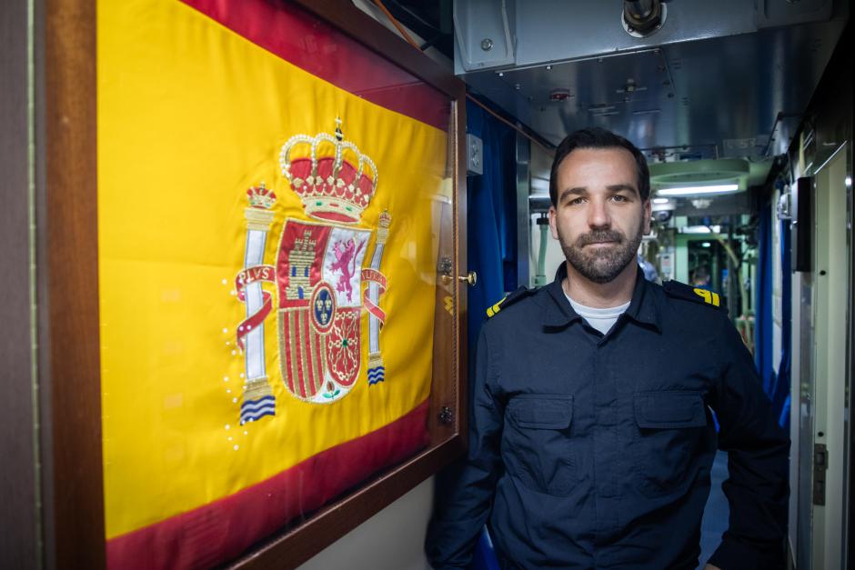 El teniente de navío Guillermo Gilabert Gamboa, junto a la bandera de España en el interior del submarino S-81