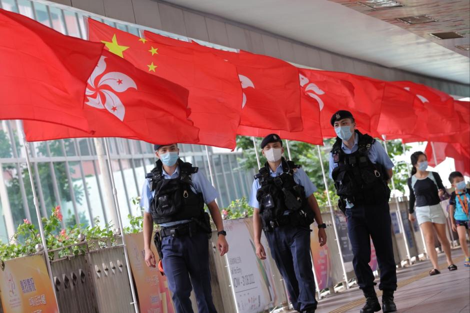 Agentes de policía caminan por un puente decorado con banderas en Wan Chai