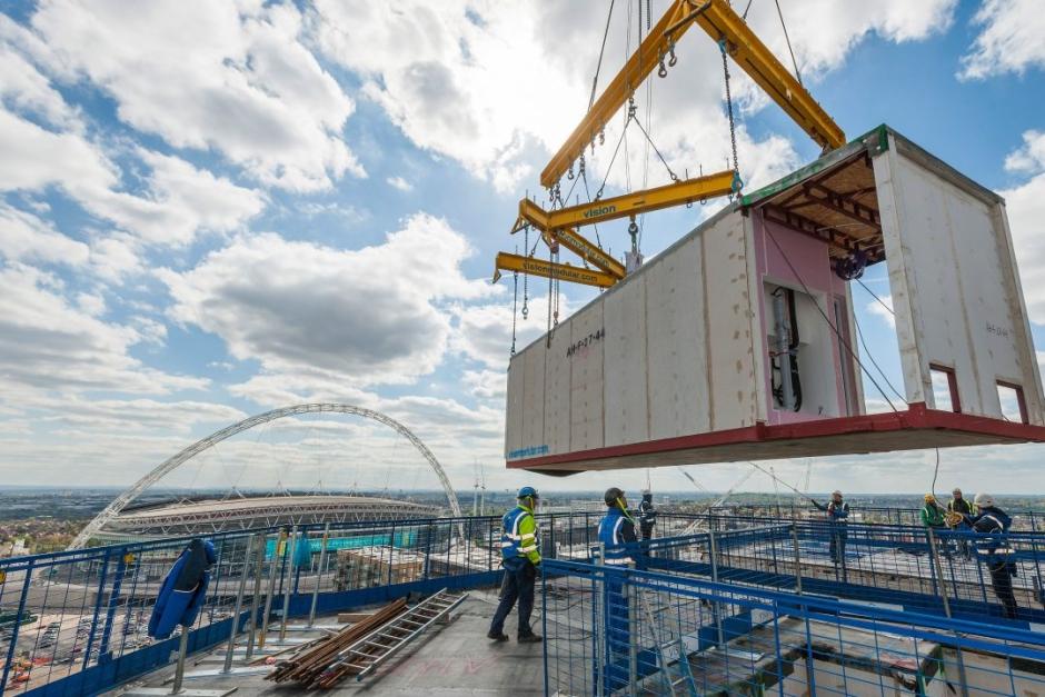 Una grúa ensambla una parte de la construcción industrializada