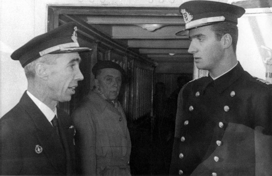 El Príncipe Don Juan Carlos conversa con el comandante del Juan Sebastián Elcano, José Ramón González López, antes de partir del puerto de Cádiz