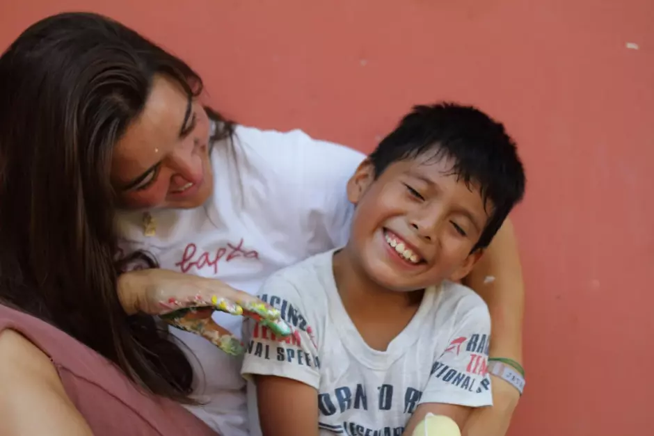 Una joven de Jatari juega con un niño en las misiones de Perú