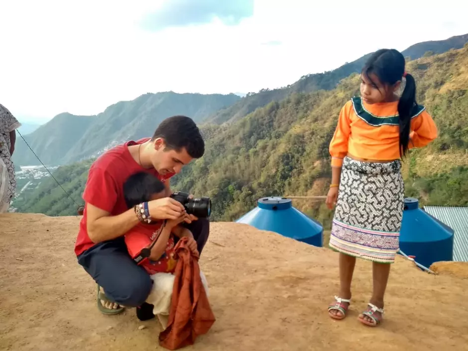 Un misionero de verano enseña a un niño a utilizar su cámara fotográfica