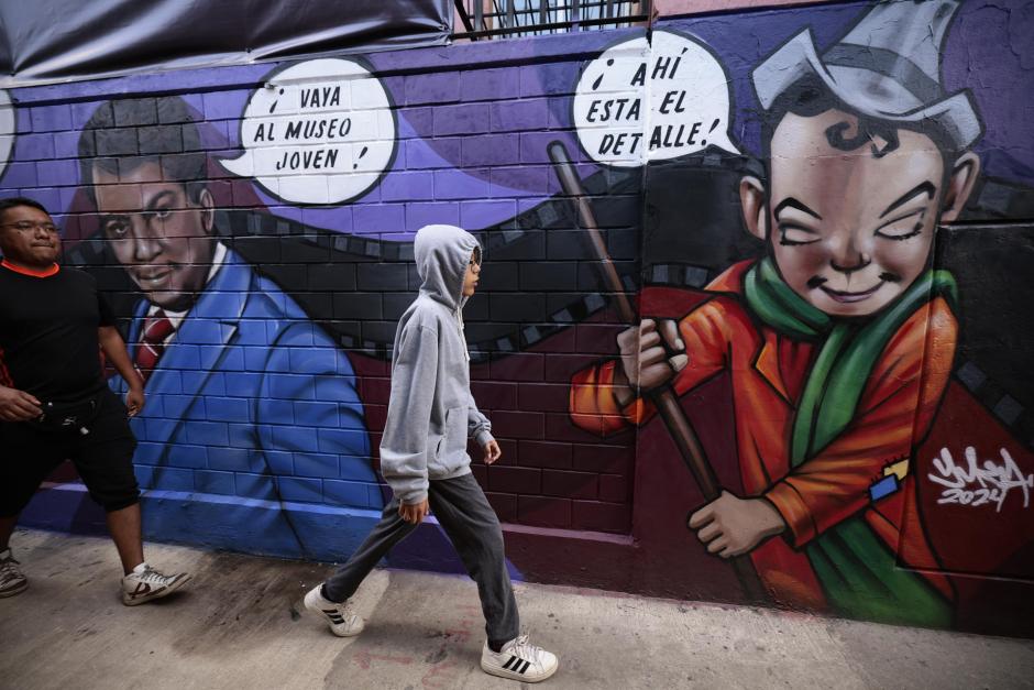 Personas caminan frente al mural dedicado al actor mexicano Mario Moreno "Cantinflas"