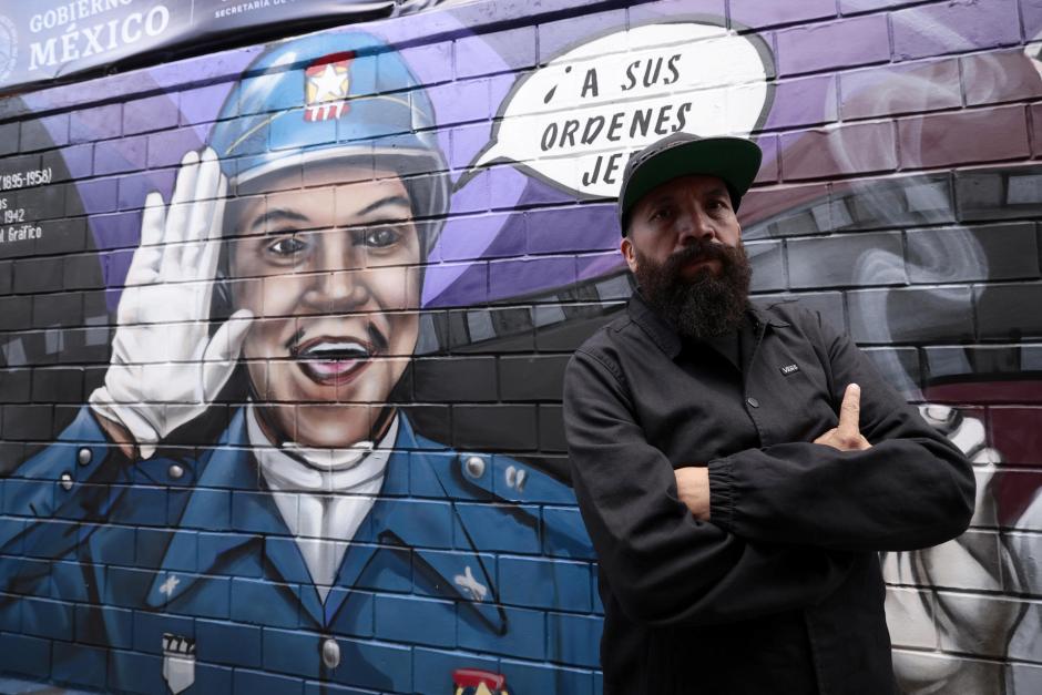 El artista urbano Yuka posa junto a su mural dedicado al actor mexicano Mario Moreno "Cantinflas",