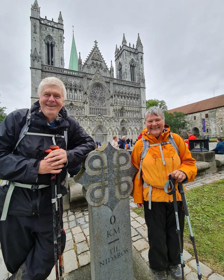 Unos peregrinos posan ante una de las estelas del Camino de San Olaf