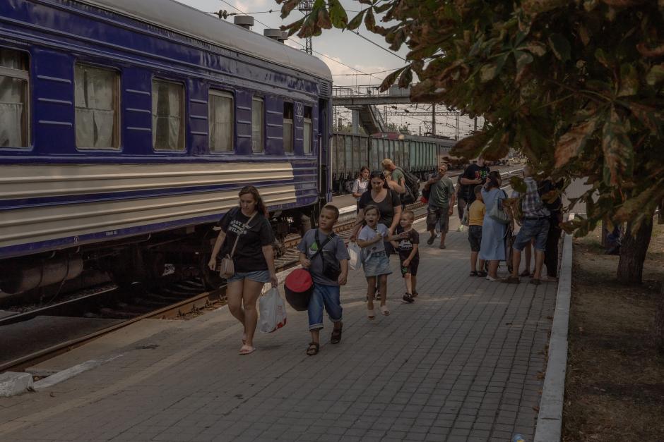 Mujeres con niños caminan para abordar un tren de evacuación en Pokrovsk, en la región oriental de Donetsk