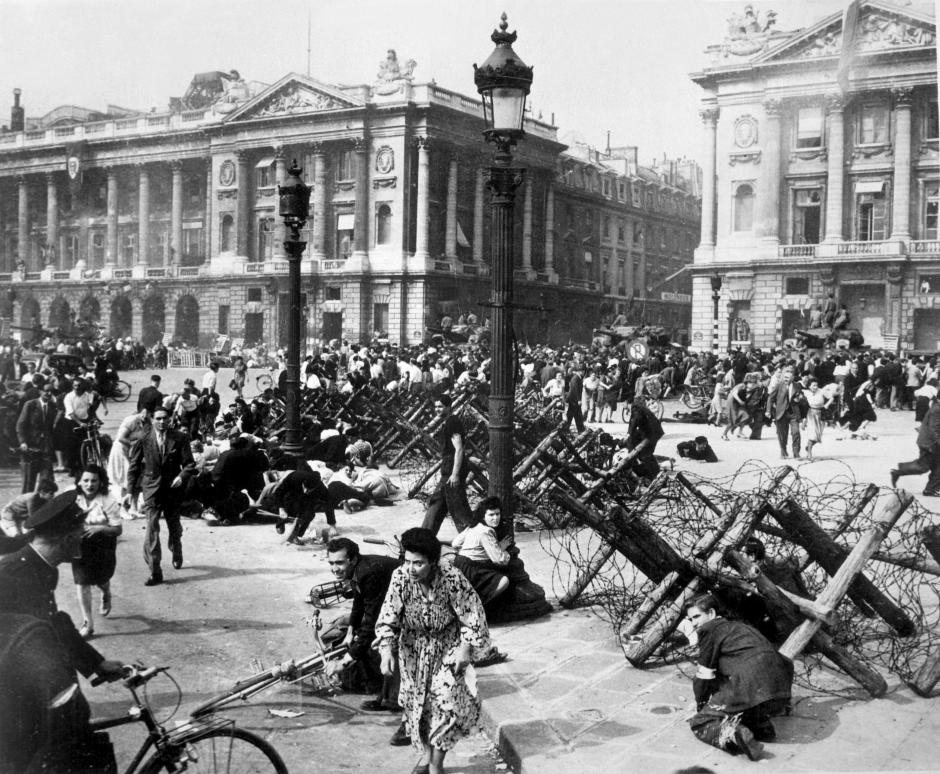 Cuando las tropas aliadas entran en París, la multitud que celebra en la plaza De La Concorde se dispersa para protegerse de los pequeños grupos de francotiradores alemanes que quedan