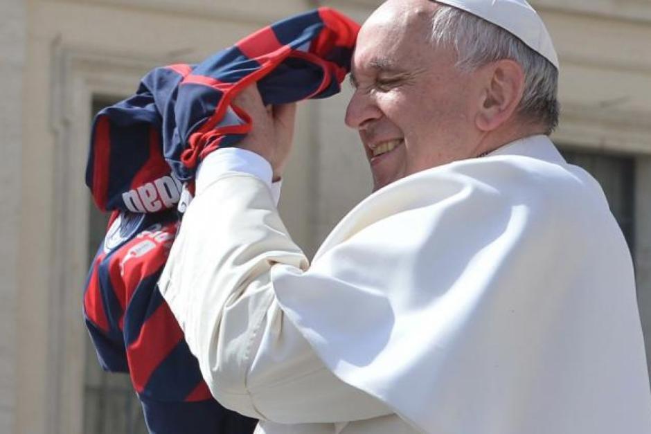 El Papa Francisco cogiendo una camiseta del San Lorenzo, su equipo favorito, que le lanzaron en una audiencia