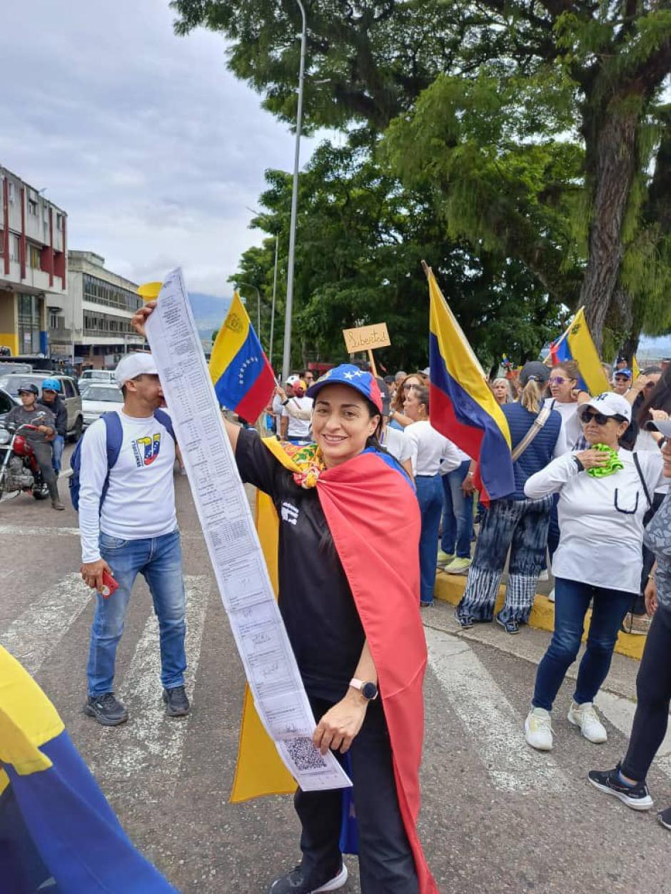 Manifestante en Caracas muestra las actas de votación