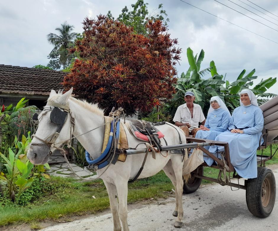 Unas Misioneras de Jesús Verbo y Víctima acuden a su catequesis en carro