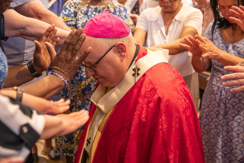 Varios feligreses rezan por su obispo durante una celebración llamada "Vida en el Espíritu"