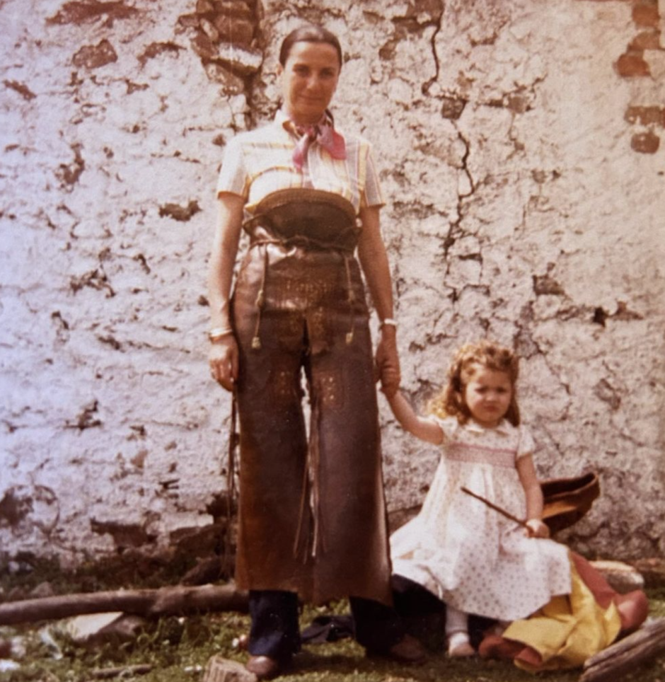 Alejandra de niña junto a su madre en el campo.