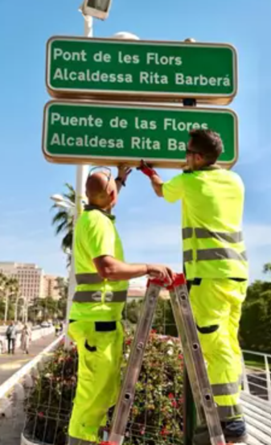 Operarios del Ayuntamiento de Valencia instalan el cartel del 'Puente de las Flores-Rita Barberá'