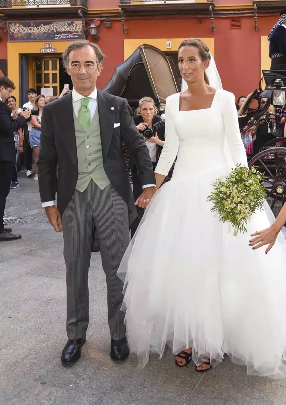 Un vestido clásico, de manga francesa, ajustado hasta la cadera, con escote cuadrado, combinado con una voluminosa falda formada por capas de tul, estilo bailarina.