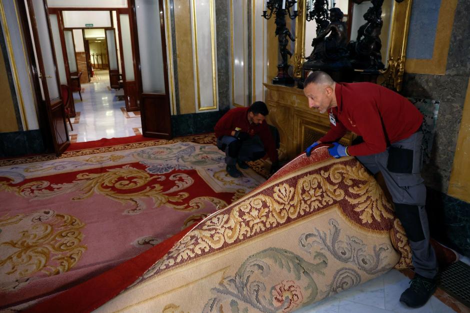 Las alfombras del Congreso son colocadas por unos operarios en una de las zonas de la Cámara Baja tras pasar varios meses en proceso de limpieza y reparación en la Real Fábrica de Tapices de Madrid por parte de las restauradoras de las mismas, que son mayoritariamente mujeres. EFE/ Chema Moya