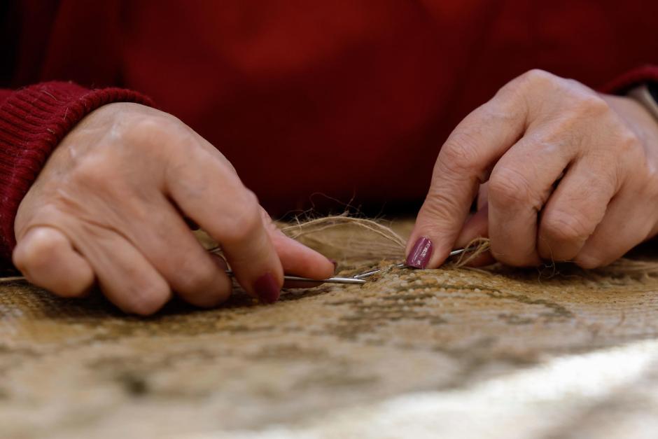 Las alfombras del Congreso son colocadas por unos operarios en una de las zonas de la Cámara Baja tras pasar varios meses en proceso de limpieza y reparación en la Real Fábrica de Tapices de Madrid por parte de las restauradoras de las mismas, que son mayoritariamente mujeres. EFE/ Chema Moya