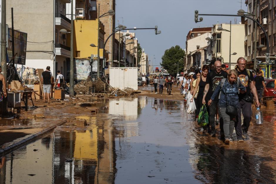 Varias personas con bolsas tras el paso de la DANA, en el barrio de la Torre, a 31 de octubre de 2024, en Valencia