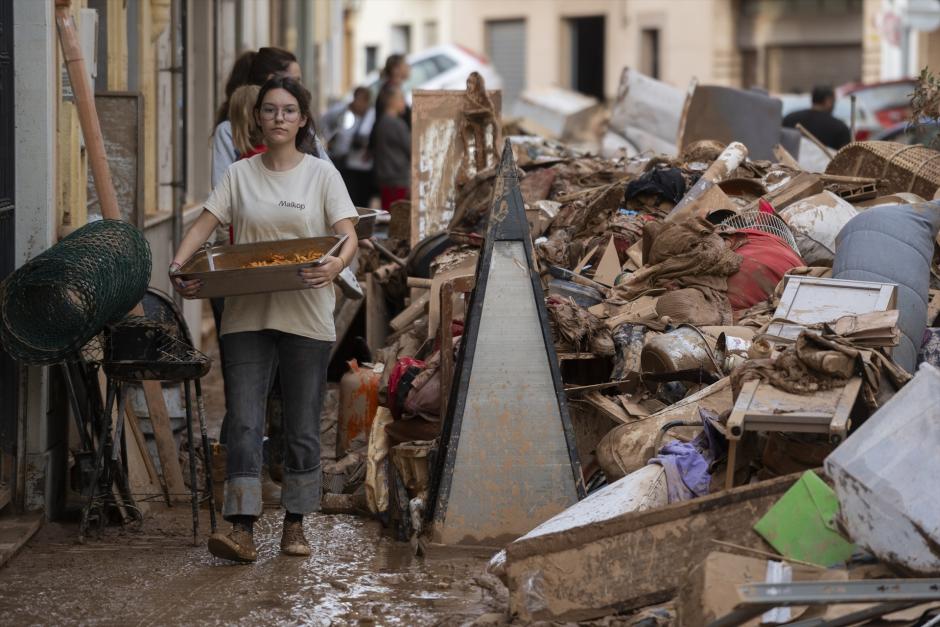 Una joven lleva comida a los afectados por la DANA, en Aldaya, Valencia, este jueves