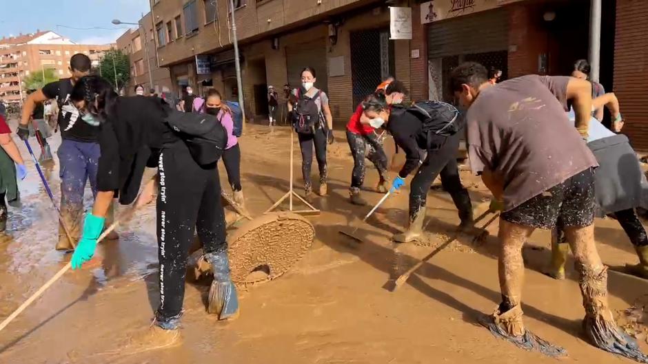 Jóvenes voluntarios ayudando en labores de limpieza por la dana