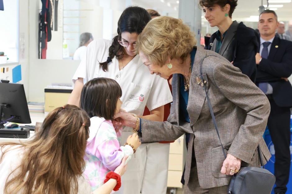 Doña Sofía saluda a una niña durante su visita al hospital