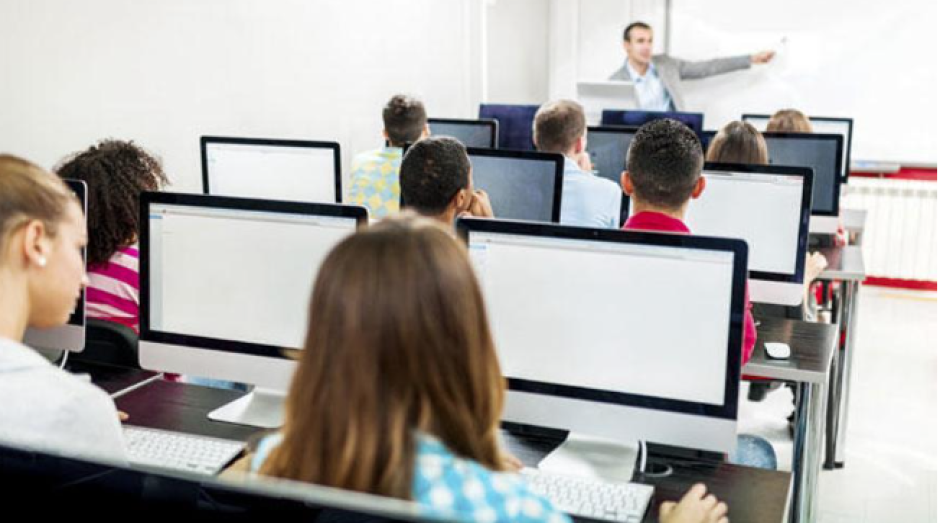 Varios alumnos usan ordenadores en una clase, en una imagen de archivo