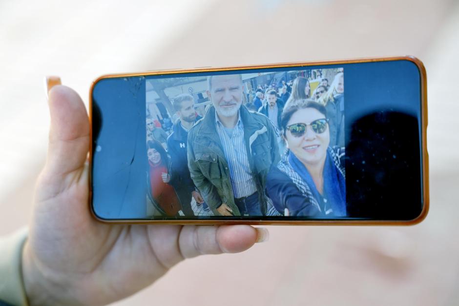 Una vecina de Catarroja muestra una foto de la visita que los Reyes Felipe y Letizia, acompañados por sus hijas, la princesa Leonor y la infanta Sofía, han realizado este domingo por sorpresa a Catarroja (Valencia), una de las localidades afectadas por la dana, en una visita privada