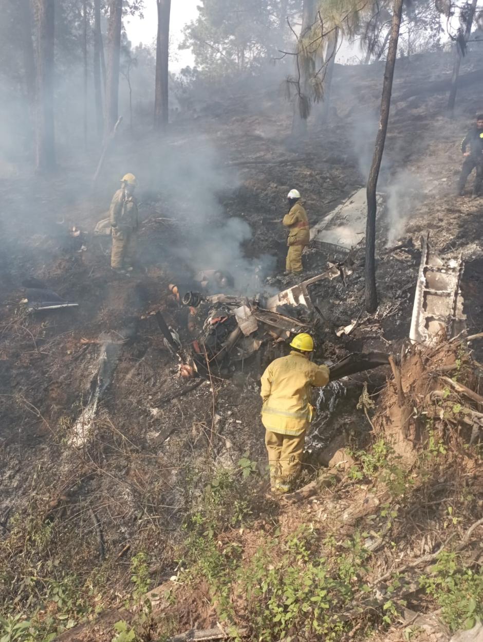 Personal de Protección Civil apagando el fuego surgido por el desplome de una avioneta en México