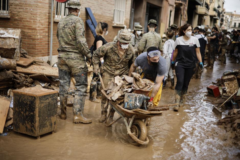 Fotografía que acompaña al Rey y en la que se ven a vecinos, voluntarios y miembros de Fuerzas Armadas, tras la dana