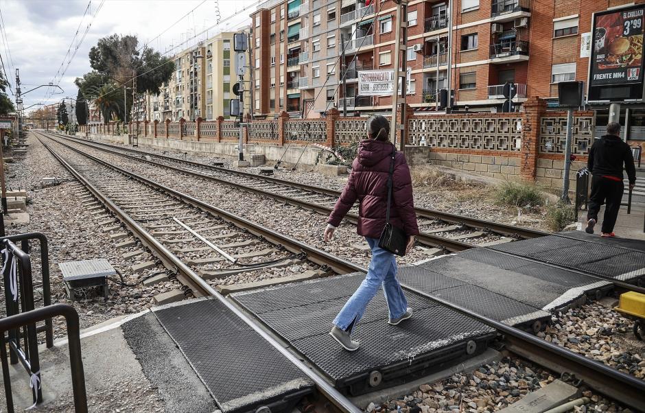 Varias personas cruzan el paso a nivel de Alfafar