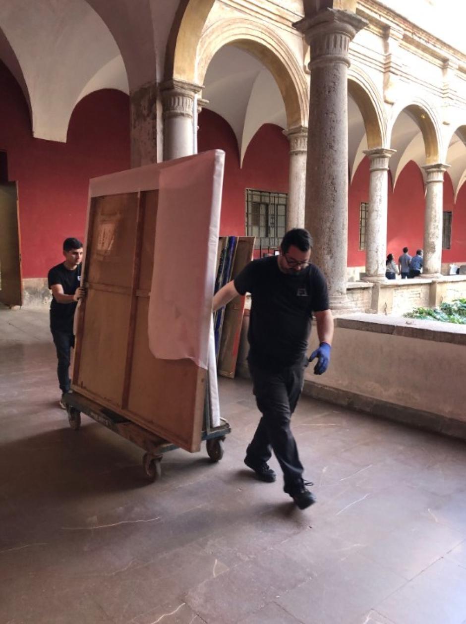 Dos operarios trasladan unas pinturas salvadas de las riadas, en Valencia