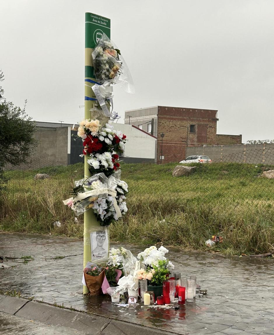 Las flores en recuerdo de Aarón tapan el poste informativo de la parada de autobuses donde fue asesinado