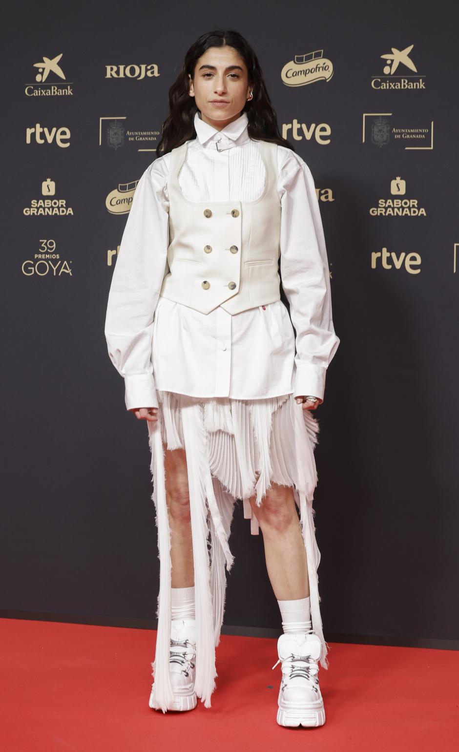 Con un modelo de chaqueta blanca, chalequillo y falda de Alexander McQueen, la Yuste chocó por parecer víctima de un atraco de dóbermans. La falda hecha jirones en distintas alturas, se acompañó de botas tipo Yeti de plataforma con calcetines. Un caso.