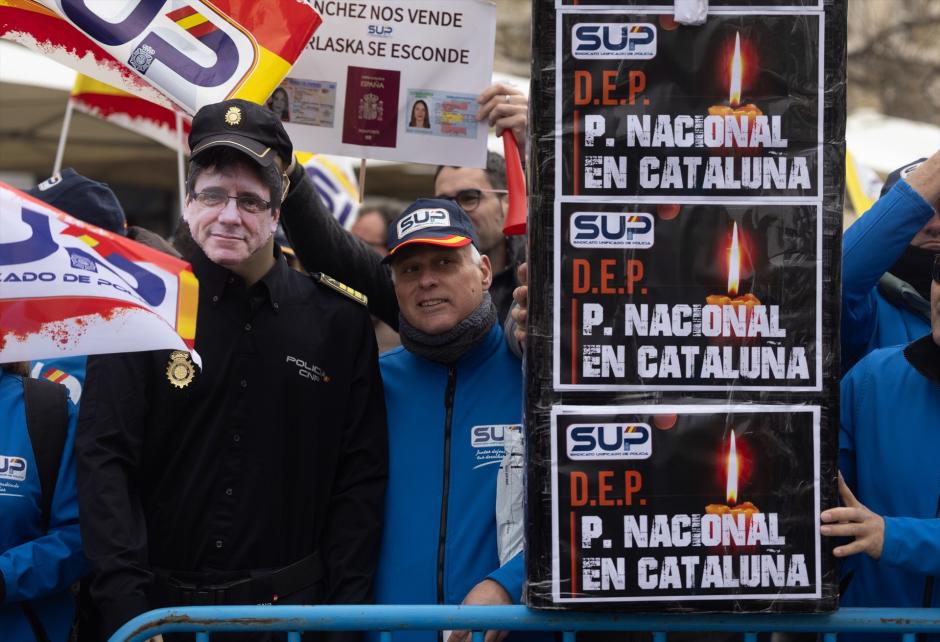 Un muñeco con la careta de Puigdemont y carteles contra el acuerdo del PSOE y Junts