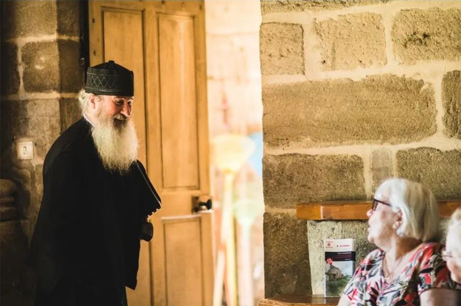Un sacerdote melquita conversa con una visitante de la abadía