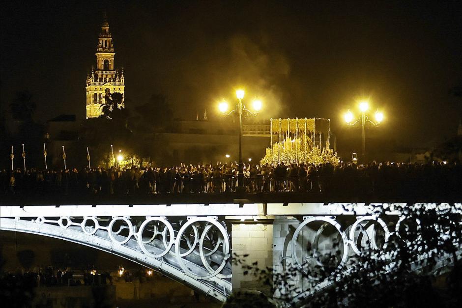 El palio de Nuestra Señora de la Esperanza cruza el Puente de Triana tras su salida de la Capilla de los Marineros para llegar a la Catedral